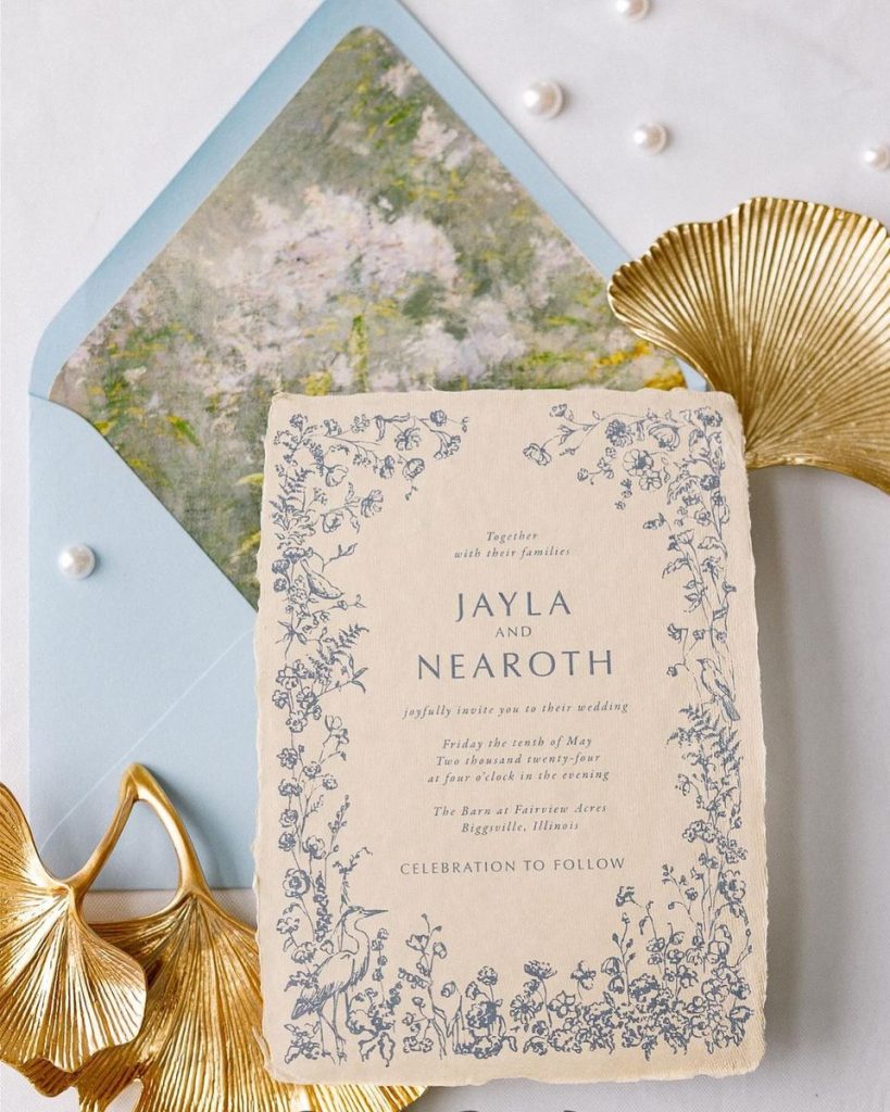 Floral wedding invitation with blue botanical border and painted envelope liner with gold decor accents