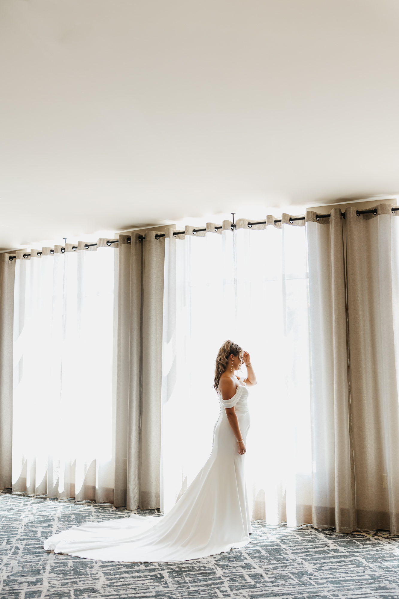 bride in wedding dress near window