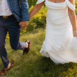 bride and groom holding hands and running