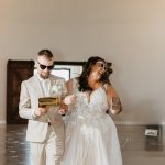 bride and groom entering reception while using a money gun