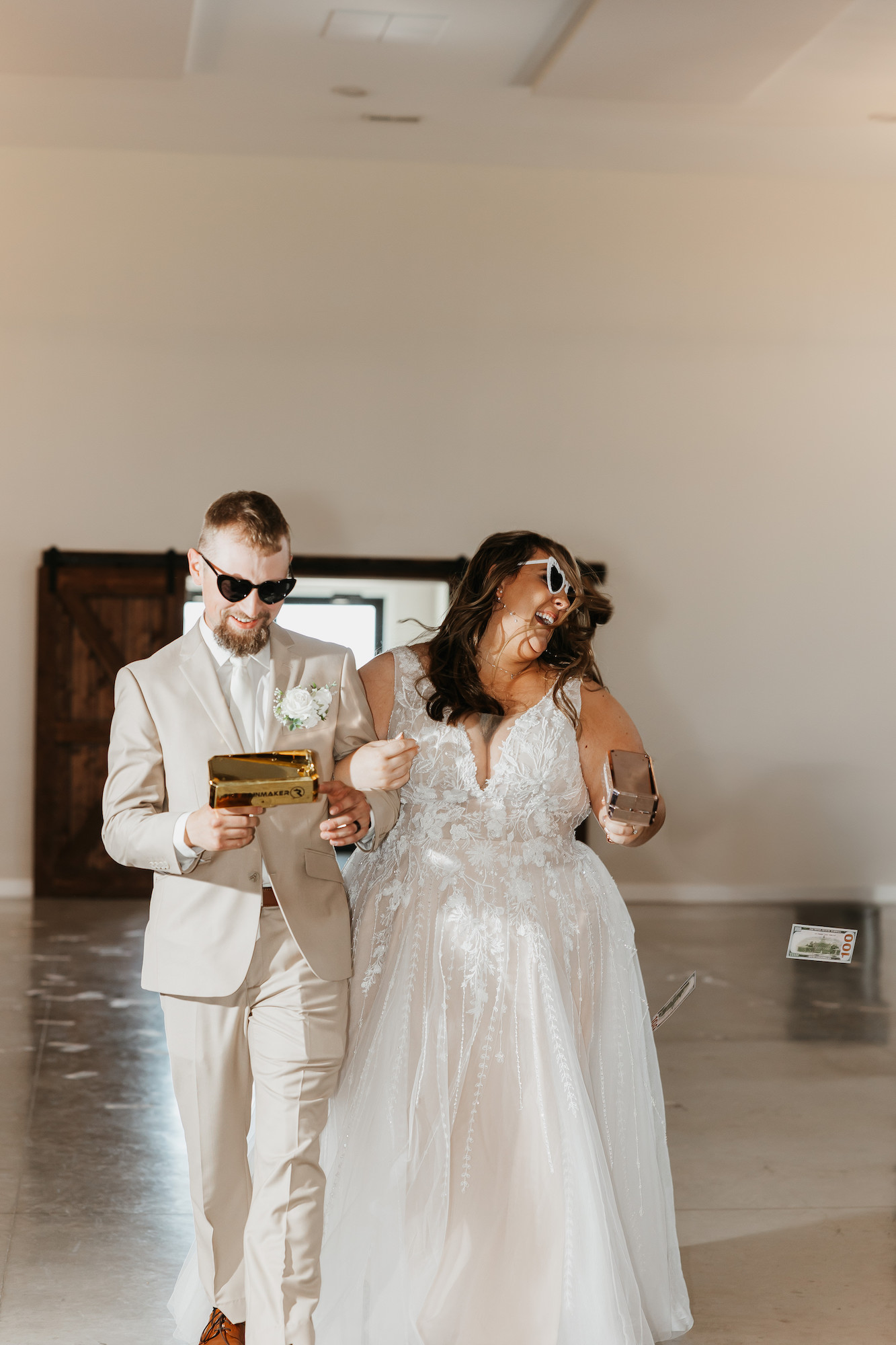 bride and groom entering reception while using a money gun