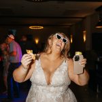 bride dancing with a late night snack of pizza at her reception