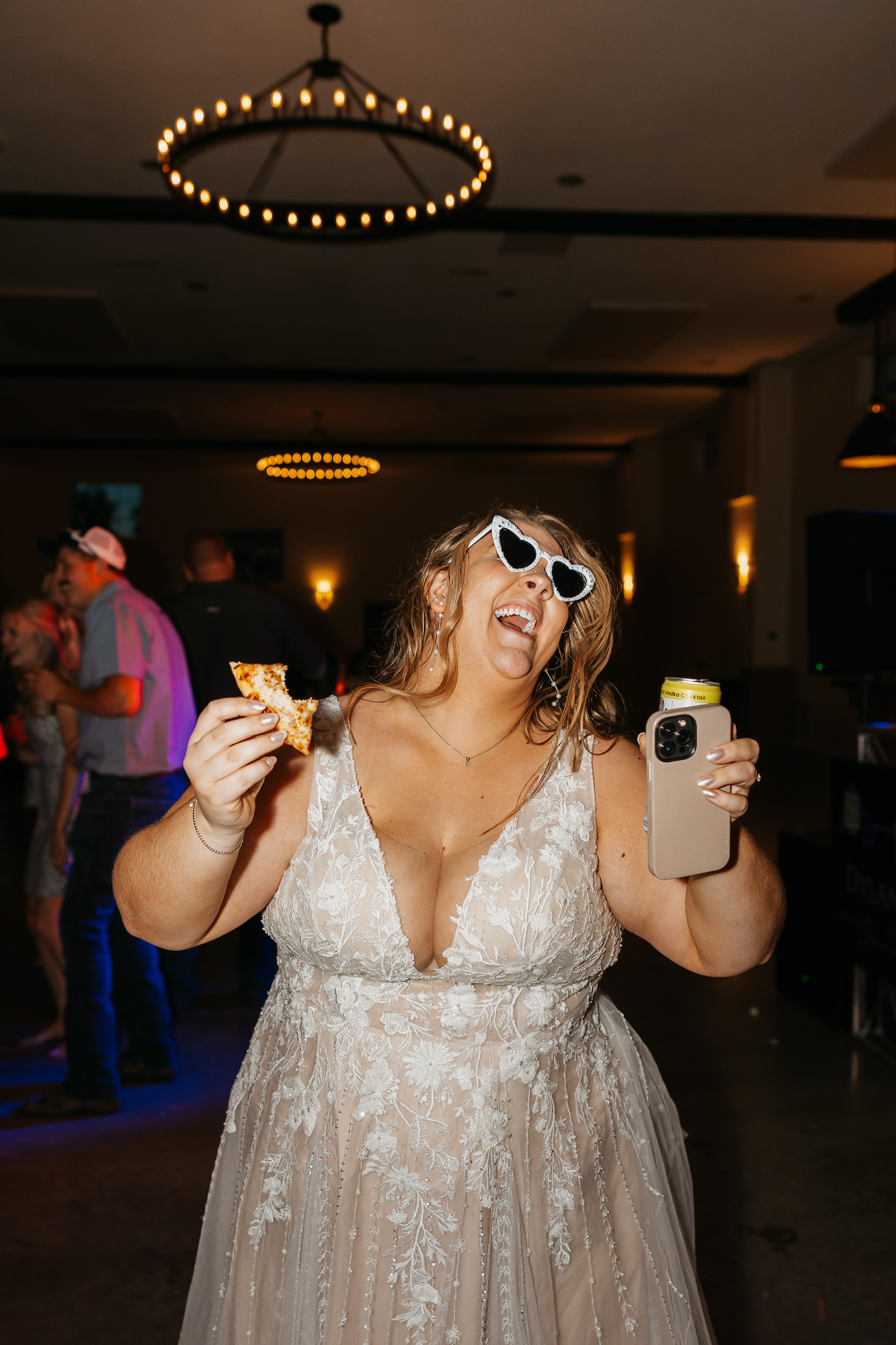 bride dancing with a late night snack of pizza at her reception