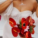 bride sipping from champagne glass while holding bouquet