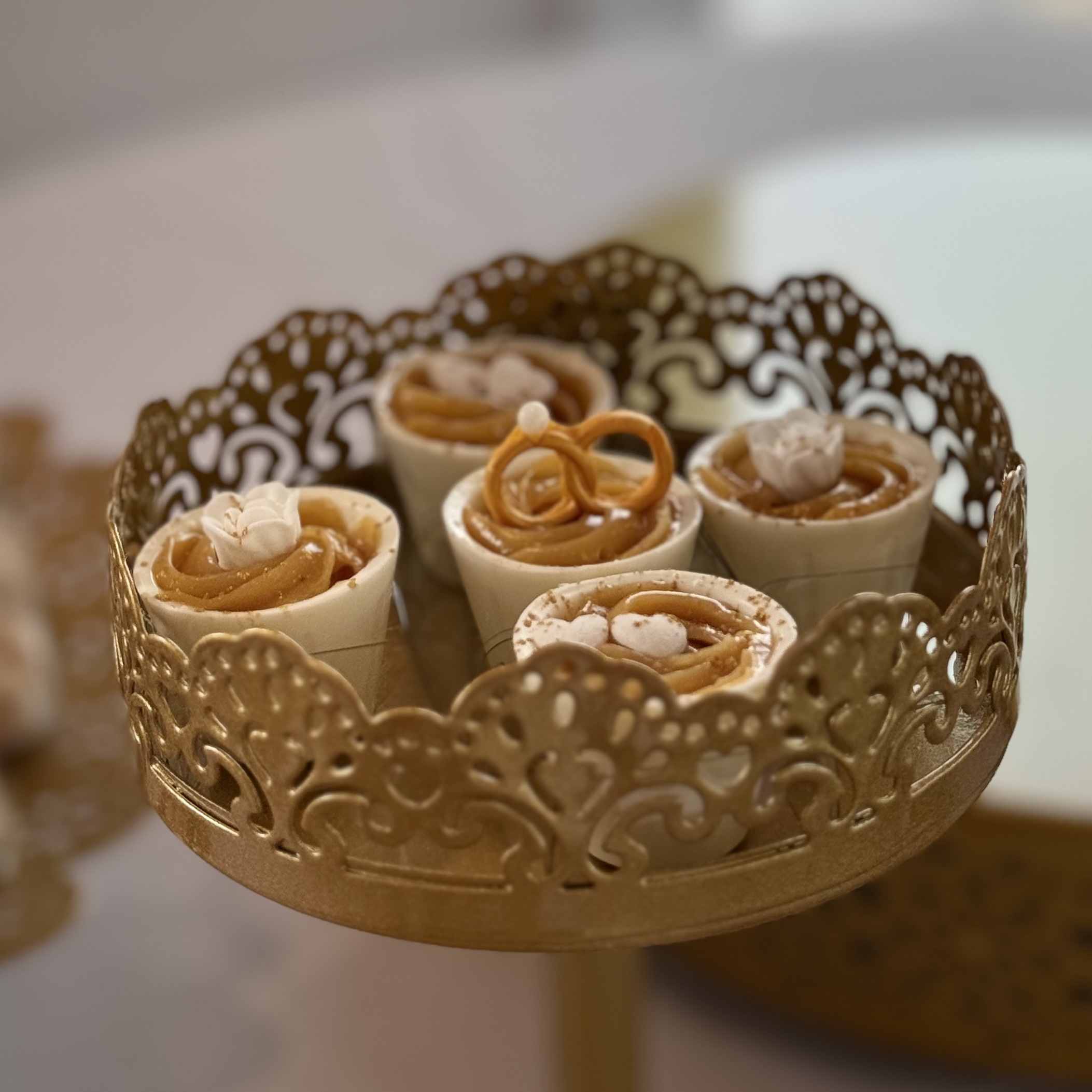 Chocolate cups with a rich passion fruit filling, beautifully decorated with edible flowers, hearts, gold glitter and wedding rings.