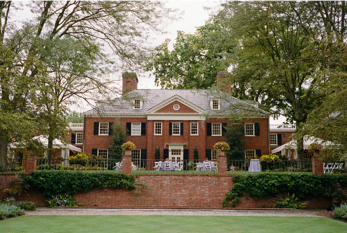 Brantwyn Estate exterior with manicured lawn and garden terrace in Wilmington, Delaware, featured as an all-inclusive wedding venue.