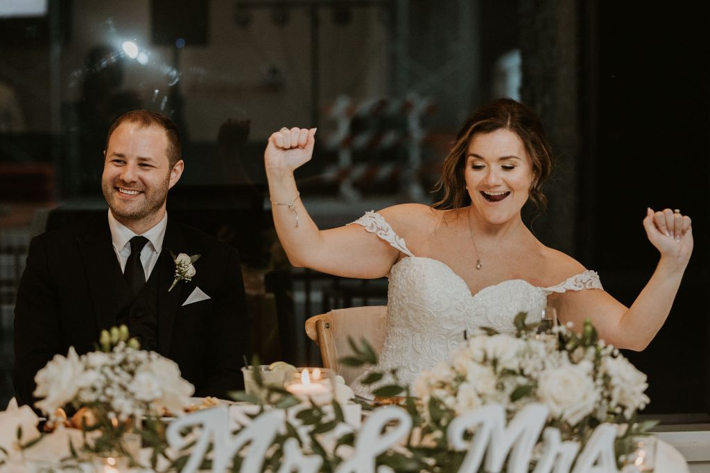 Bride and groom celebrating at an intimate wedding reception in downtown Wilmington, Delaware, with candlelit table décor and a lively, modern atmosphere