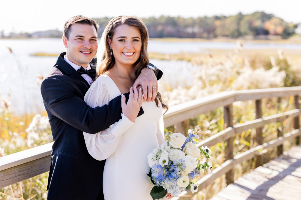 Bride and groom portrait at Bayside Resort Golf Club in Selbyville, Delaware, overlooking the Assawoman Bay with coastal marsh views and waterfront scenery