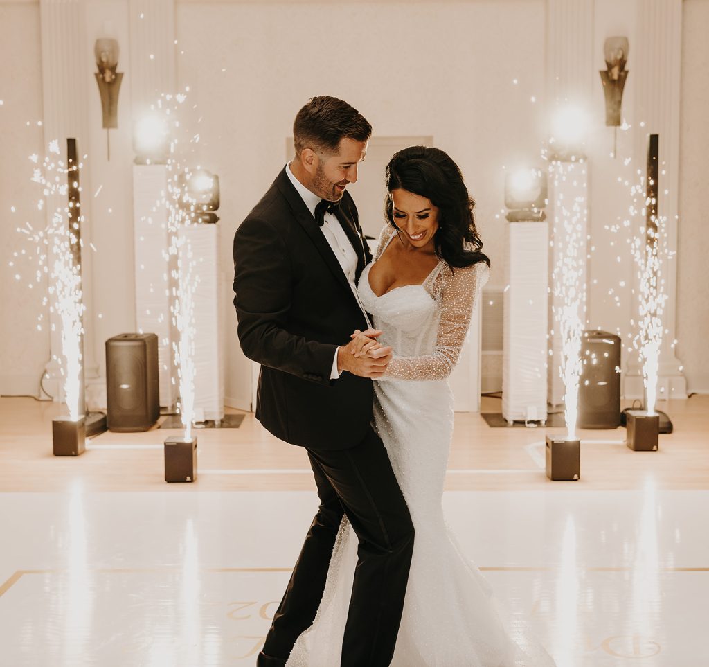 Newlyweds share first dance surrounded by sparkling pyrotechnic fountains