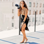 Wedding photographer holds camera on urban rooftop terrace