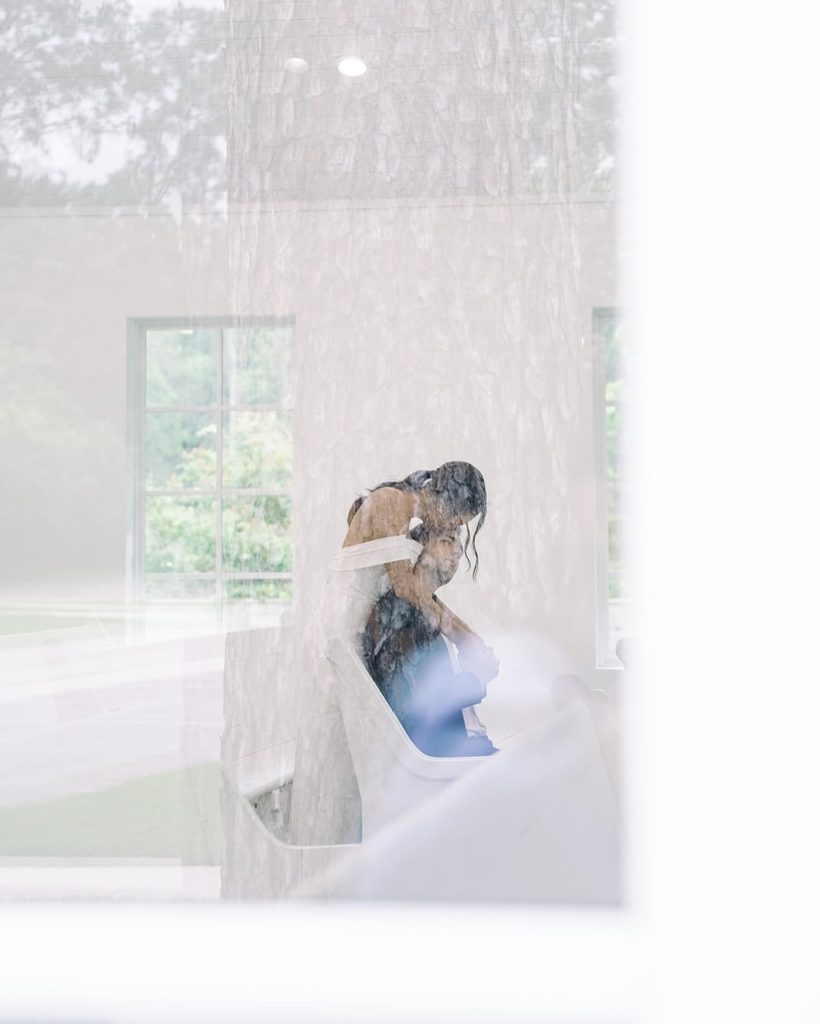 Bride in flowing veil captured in ethereal double exposure through window