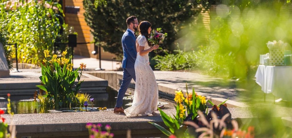 Bride and groom sharing first kiss at outdoor Denver botanical garden ceremony