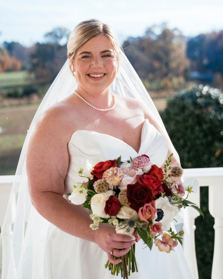 bride with a red and white bouquet with a sweetheart strapless dress line gown