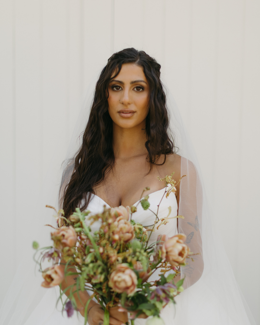 bride with wavy half up half down hair and soft glam makeup
