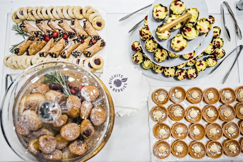 Assorted wedding dessert display featuring cookies, cannolis, cupcakes, and mini tarts from Biscuits & Berries bakery