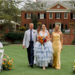 Bride in blue tulle gown walking down the aisle with parents during outdoor ceremony at Brantwyn Estate in Wilmington, Delaware, featured in all-inclusive wedding venue setting.