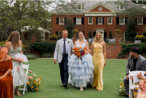 Bride in blue tulle gown walking down the aisle with parents during outdoor ceremony at Brantwyn Estate in Wilmington, Delaware, featured in all-inclusive wedding venue setting.