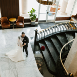 Aerial view of hotel's elegant marble lobby with grand piano and sweeping staircase