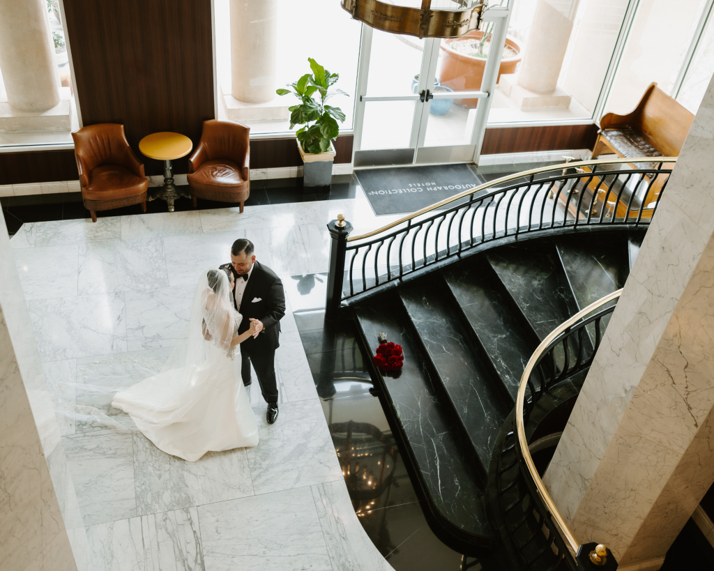 Aerial view of hotel's elegant marble lobby with grand piano and sweeping staircase