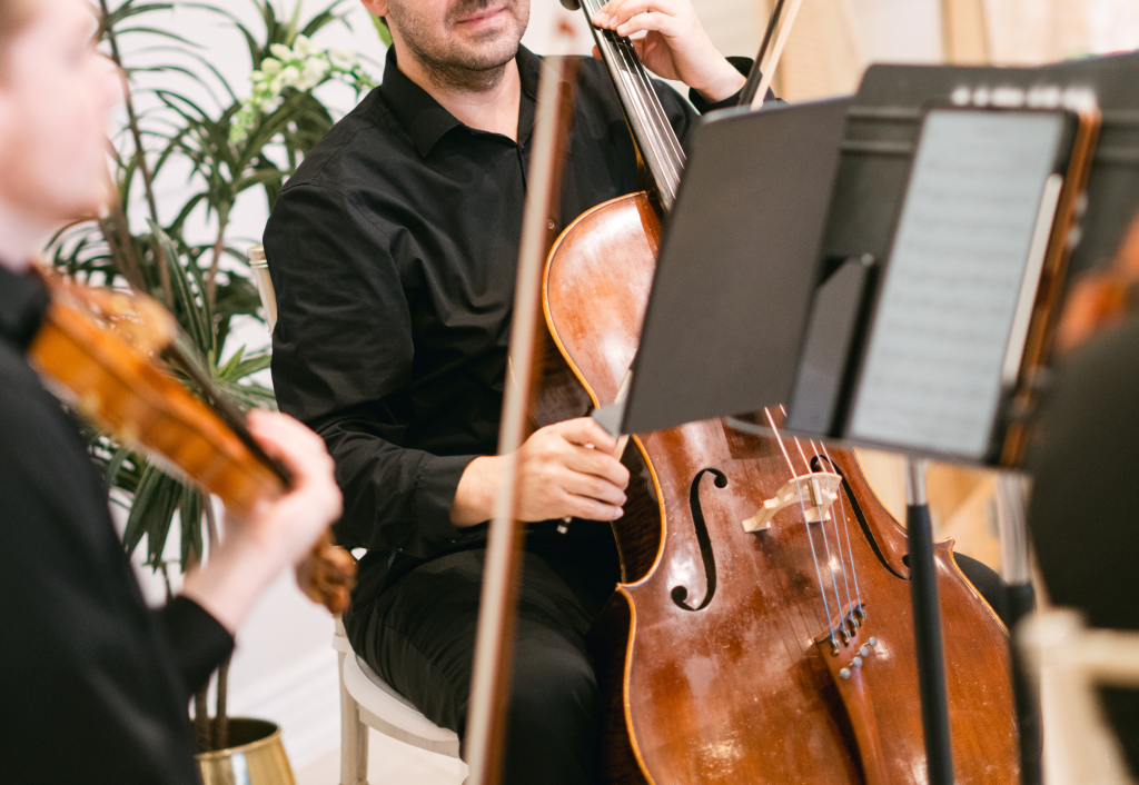 Cellist performing in formal attire during romantic proposal setup