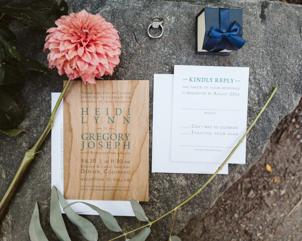 Wood wedding invitation suite with pink dahlia, engagement ring, and navy gift box