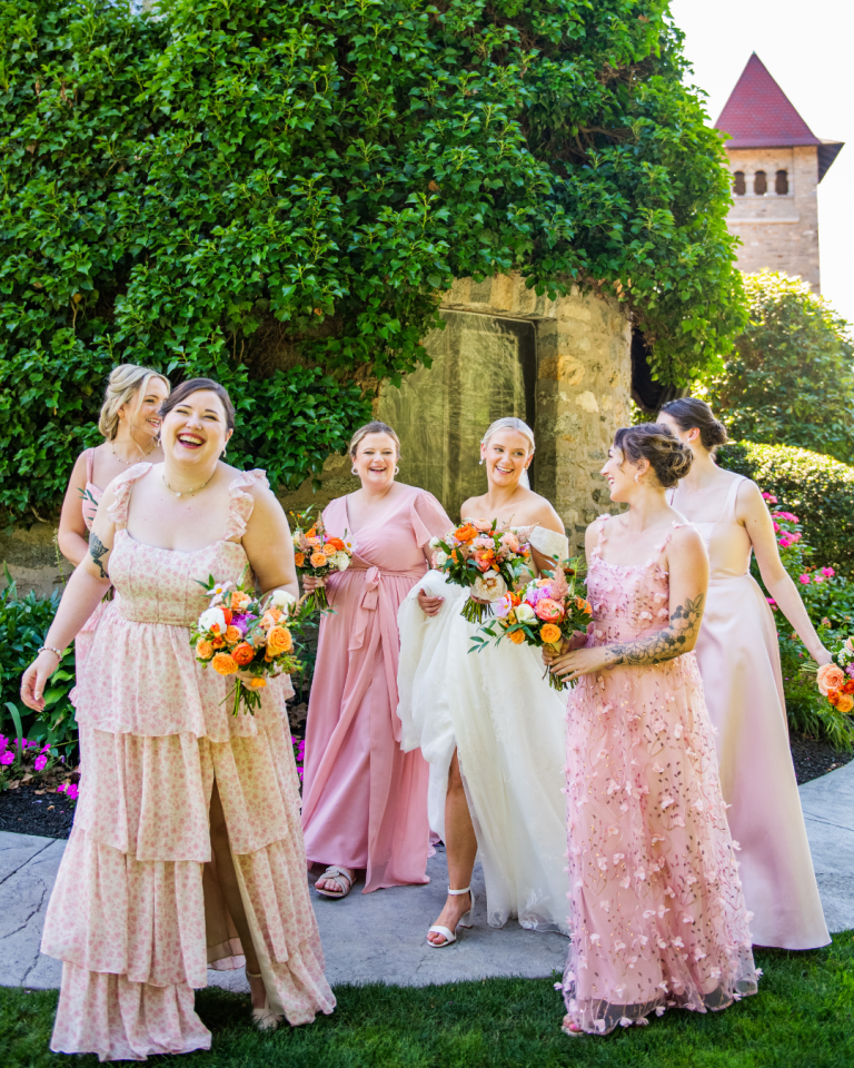 happy bridesmaids in pink dresses walking and laughing with eachother