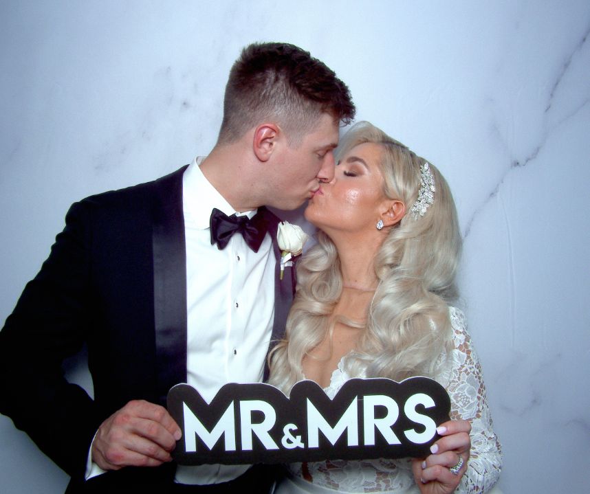 couple holding prop in photo booth