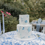 two tiered white wedding cake with blue buttercream accents