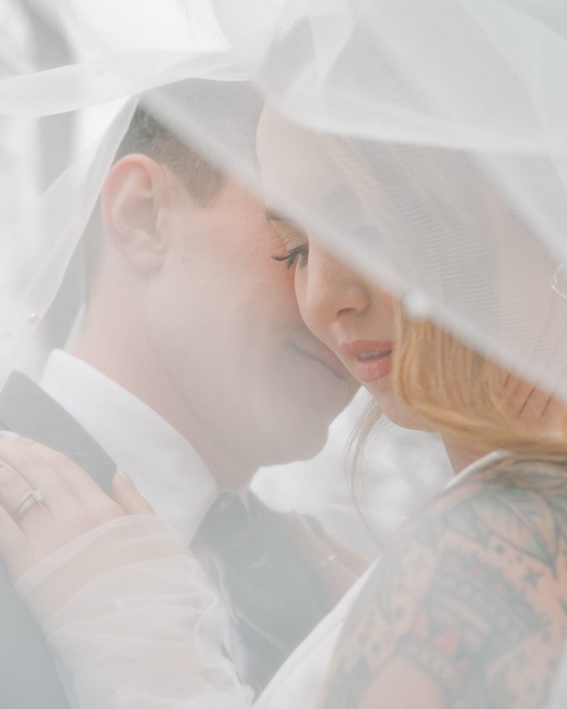 Couple shares intimate moment under wedding veil