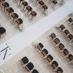 Aerial view of wedding ceremony setup with geometric aisle design and gold chairs