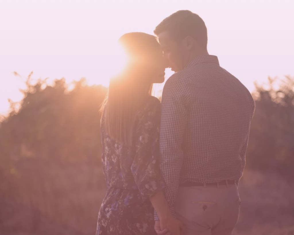 Couple embracing at sunset in natural outdoor setting