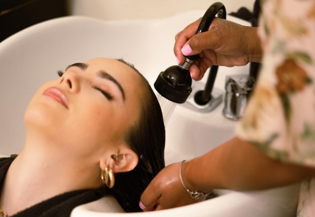 Bride receiving professional hair wash treatment at salon during bachelorette spa day