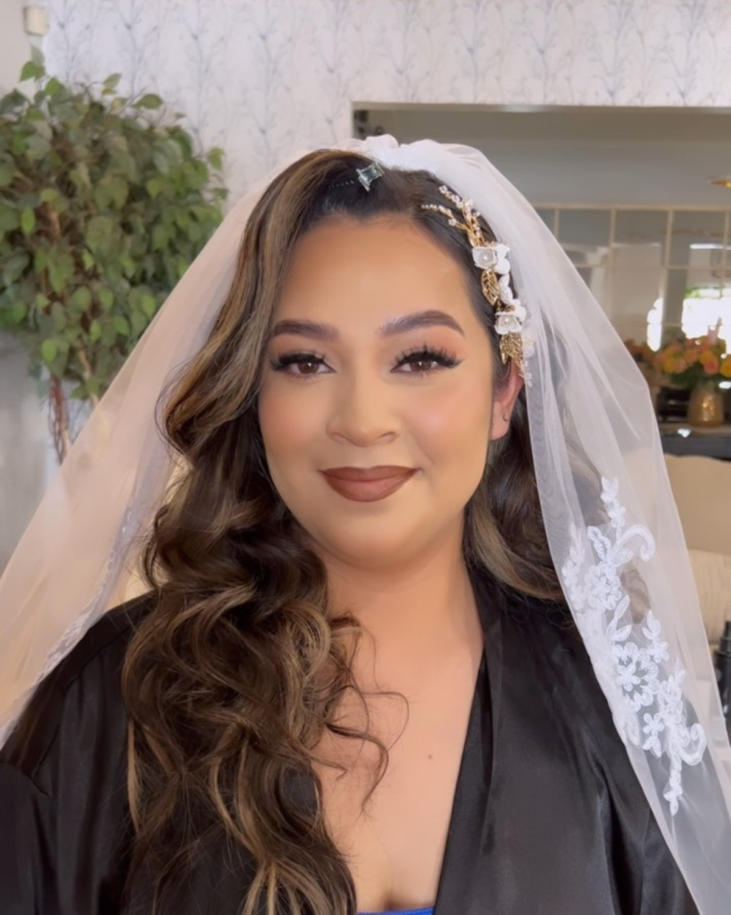 Bride wearing white veil with gold butterfly hair accessories and glamorous makeup