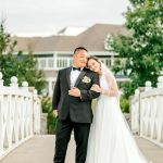 Bride in flowing gown and groom in tuxedo on bridge at Indianapolis reception venue