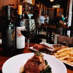 Seared pork chop with mashed potatoes and broccoli served with red wine