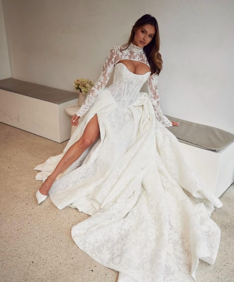 Bride Cassidy in lace wedding gown with long sleeves, cutout bodice, and dramatic train