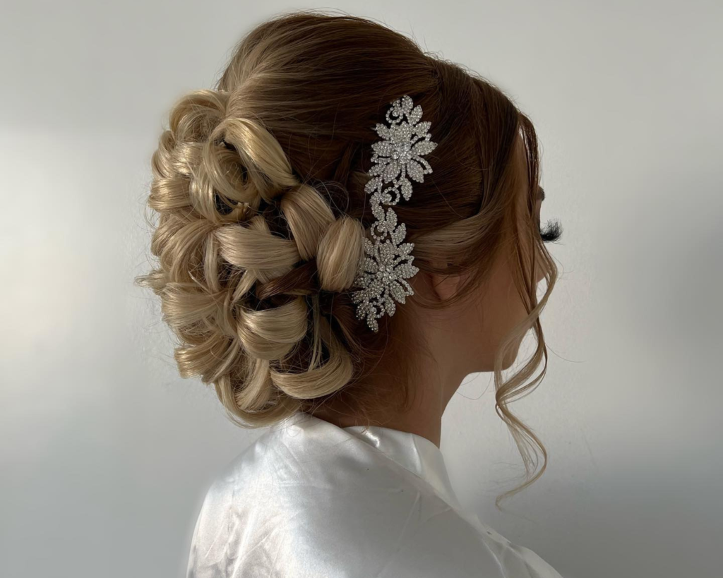 Elegant bridal updo with intricate braided bun and sparkling crystal hair comb accessory