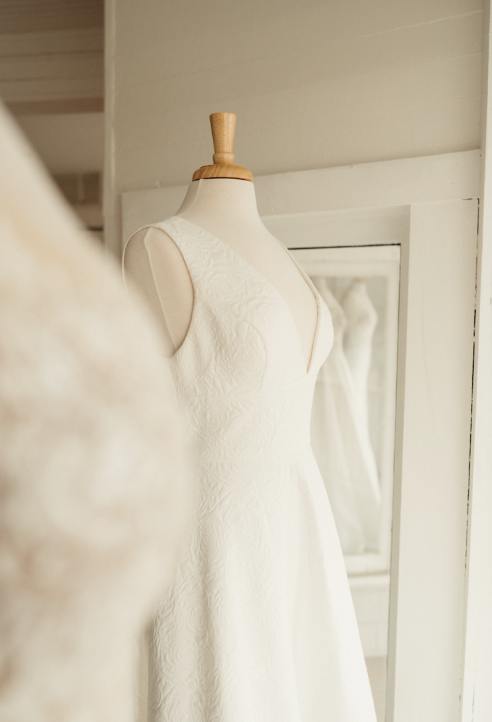 Close-up of white wedding dress with textured fabric on dress form
