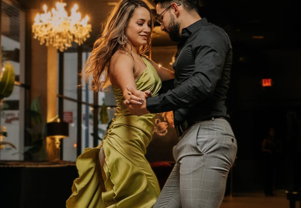 Couple dancing together in elegant attire beneath chandelier at The Garrison cocktail bar
