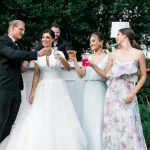 Wedding guests toasting with cocktails at outdoor garden reception