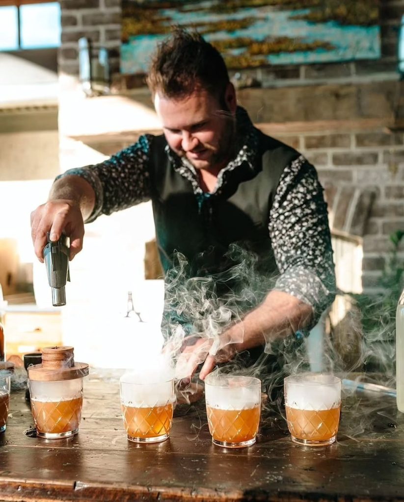 Bartender creating dramatic smoking cocktails with dry ice at wedding reception