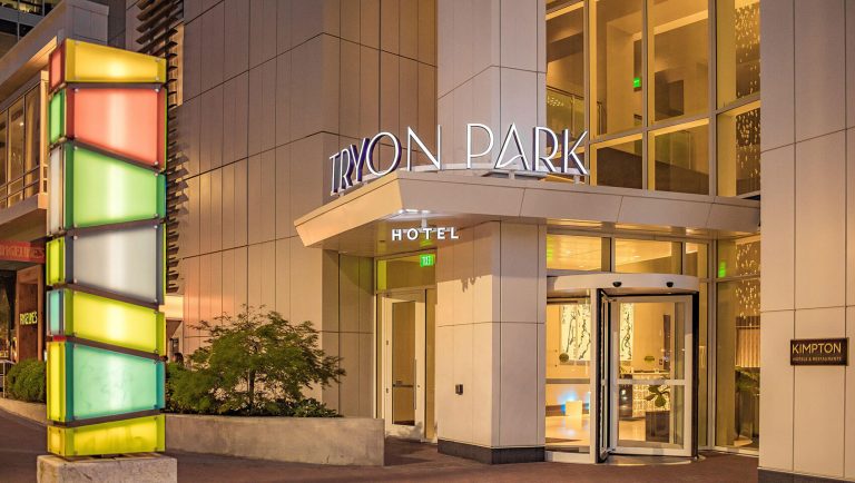 Tryon Park Hotel entrance at dusk with illuminated signage and colorful geometric light installation in Charlotte