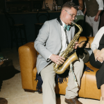 Saxophone player, playing in a moody bar on a couch
