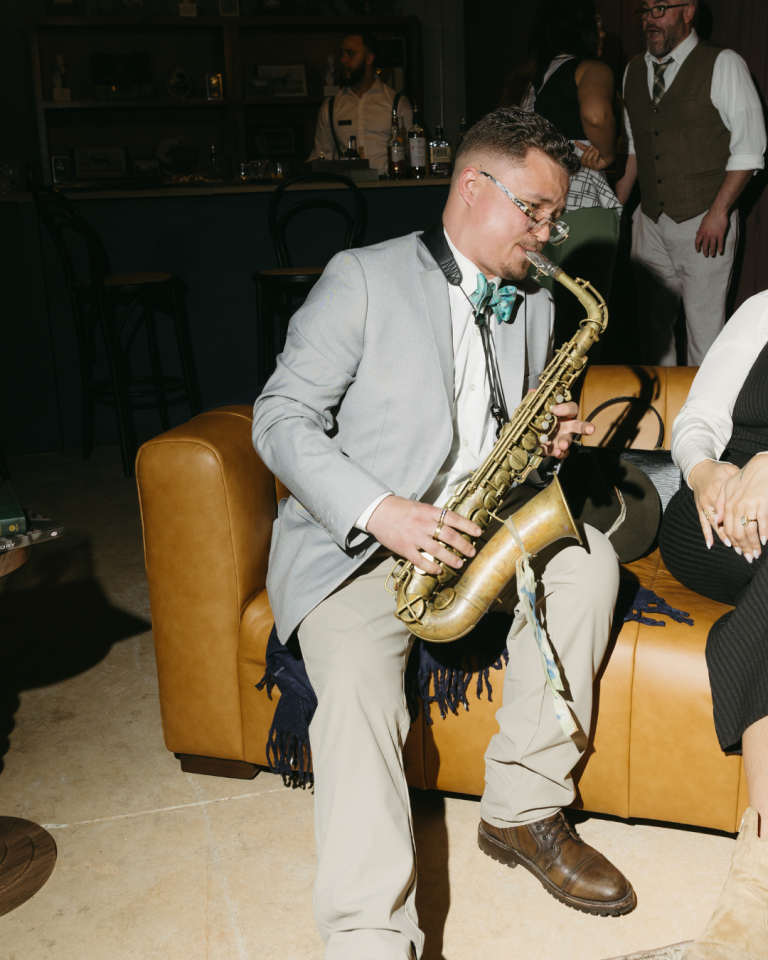 Saxophone player, playing in a moody bar on a couch