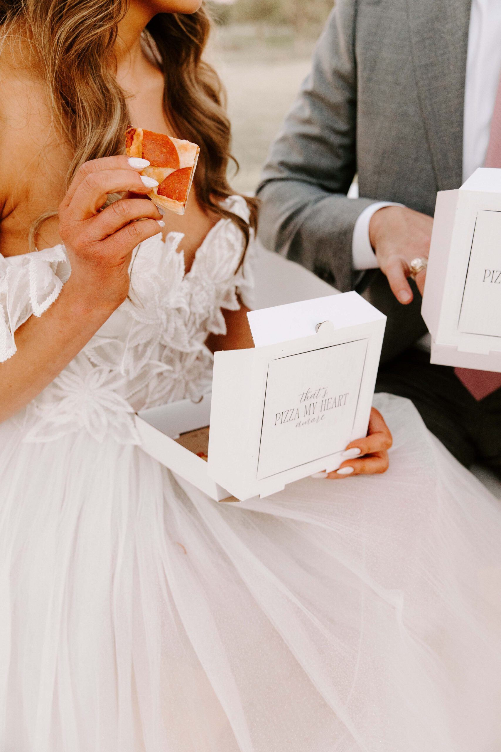 couple enjoying their personalized pizza as a wedding reception favor
