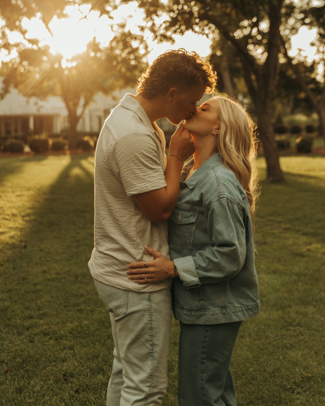 Engaged couple sharing intimate moment outdoors during golden hour photoshoot