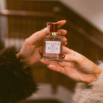 Bride holding Atelier de Fleur perfume bottle with rose gold cap