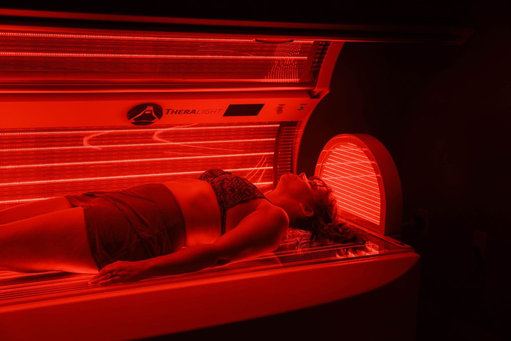 Client lying in red light therapy bed