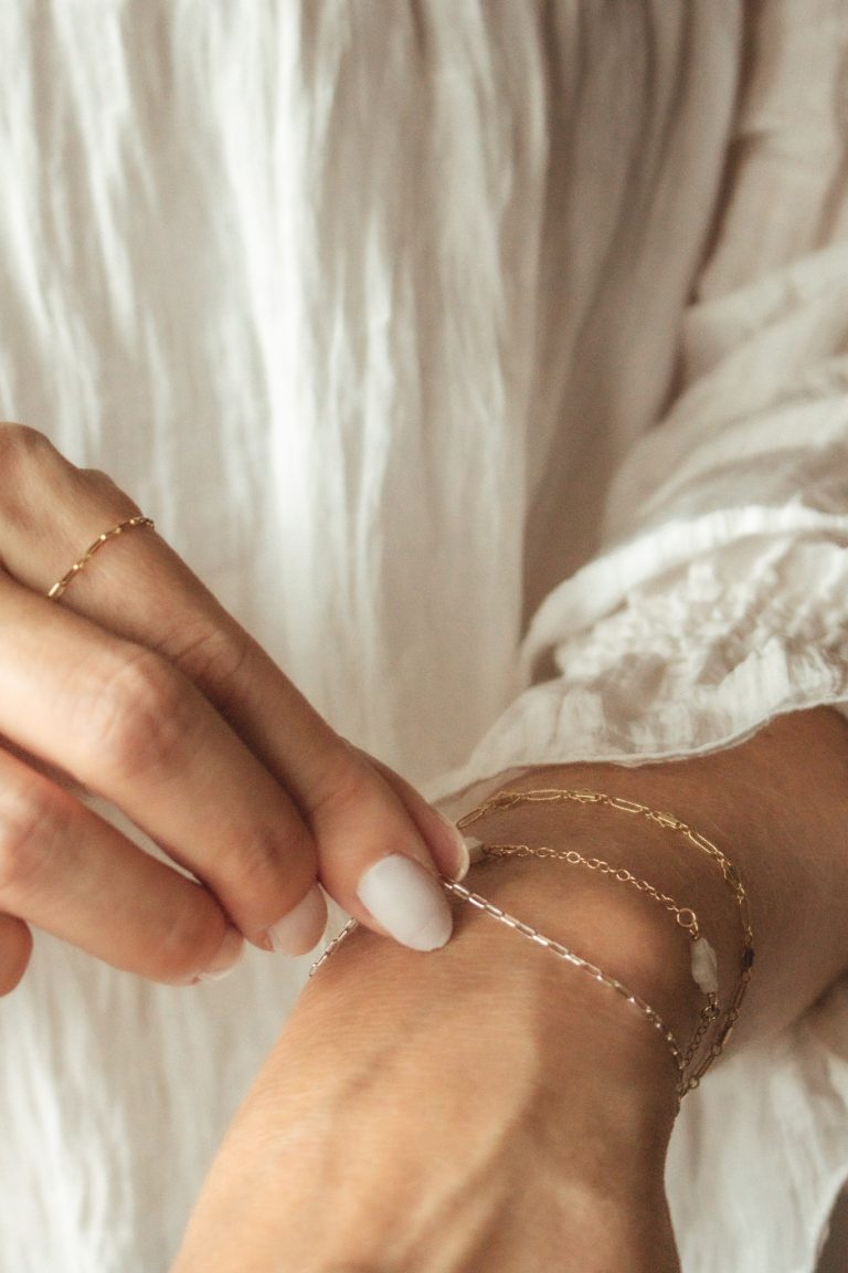 Bride's diamond engagement ring and wedding bands on hands with lace dress