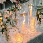 Candles flicker across tables for wedding reception